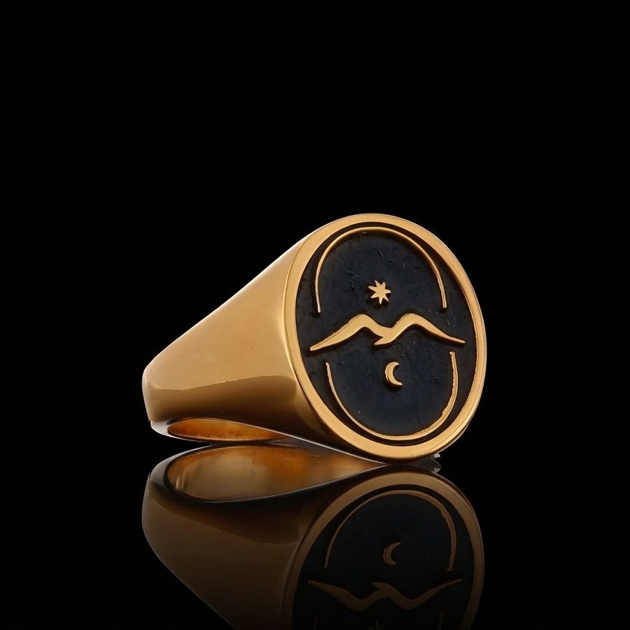 Gold signet ring with a black face engraved with a bird in flight, a crescent moon and a star