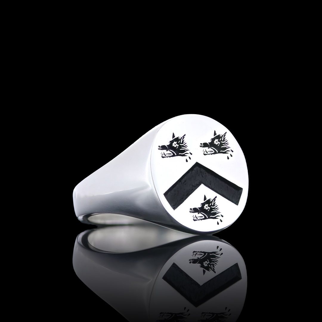 Silver signet ring with a polished face engraved with a chevron between three heraldic beasts' heads